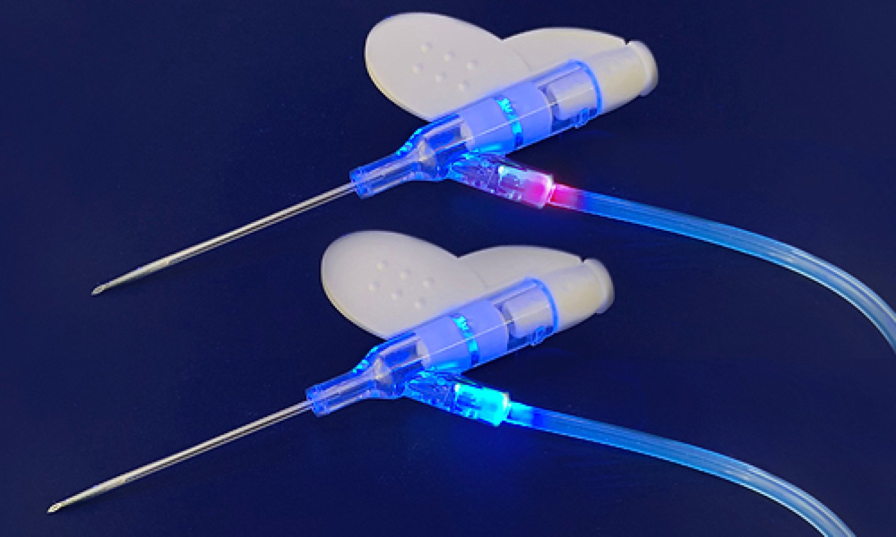 Two catheters bonded with Dymax light-curable adhesives fluoresce blue and red.